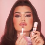 Dakota applying Pillow Talk Big Lip Plumpgasm plumping lip gloss to make lips look bigger
