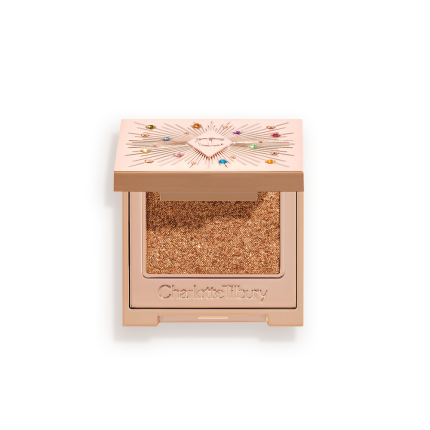An open, single-pan eyeshadow with a mirrored lid in an iridescent orange-gold shade with very fine shimmer. 