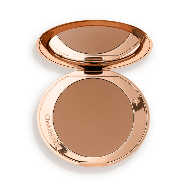 An open mirrored-lid bronzer compact in a medium-brown shade.