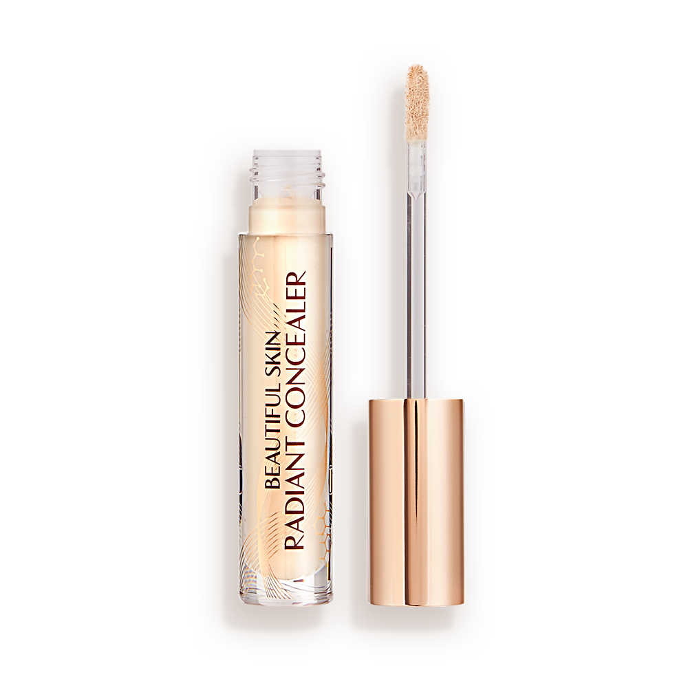 BSC-Packshot-1-Open Light beige radiant concealer in a glass tube with its gold-coloured lid with a doe-foot end next to it, and text on the tube that reads, 'Beautiful Skin Concealer'