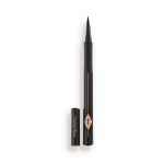 An open eyeliner pen in jet-black packaging with the iconic CT logo embossed on it and its cap next to it.