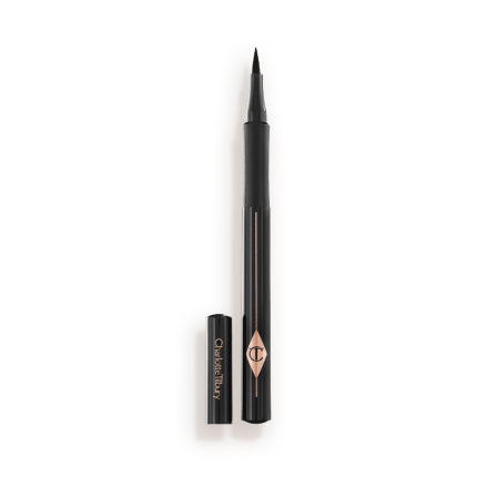 An open eyeliner pen in jet-black packaging with the iconic CT logo embossed on it and its cap next to it.