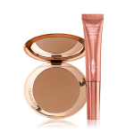 An open, mirrored-lid bonzer compact with a warm-brown bronzer and a highlighter-blush wand in a warm pink shade.