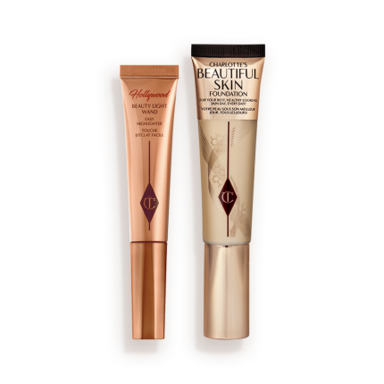 Highlighter wand in light gold-coloured packaging with a foundation wand in gold packaging with a ashy brown-beige-coloured body to show the shade of the foundation inside, and a gold-coloured lid.