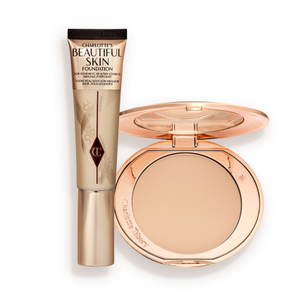 A foundation wand in gold packaging with a brown-beige-coloured body to show the shade of the foundation inside, and a pressed powder compact with a mirrored lid.