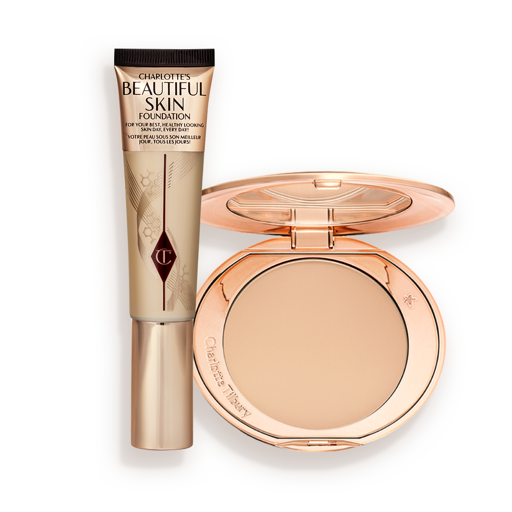 CHARLOTTEa__S_BEAUTIFUL__FLAWLESS_LOOKING_SKIN_KIT-BUNDLE A foundation wand in gold packaging with a brown-beige-coloured body to show the shade of the foundation inside, and a pressed powder compact with a mirrored lid.