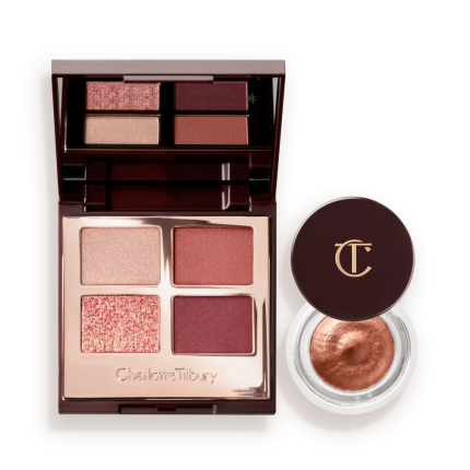An open, mirrored-lid quad eyeshadow palette with beige, rose gold, russet brown, and maroon shades and cream eyeshadow in a nude pink shade in a petite, open pot with its lid removed.