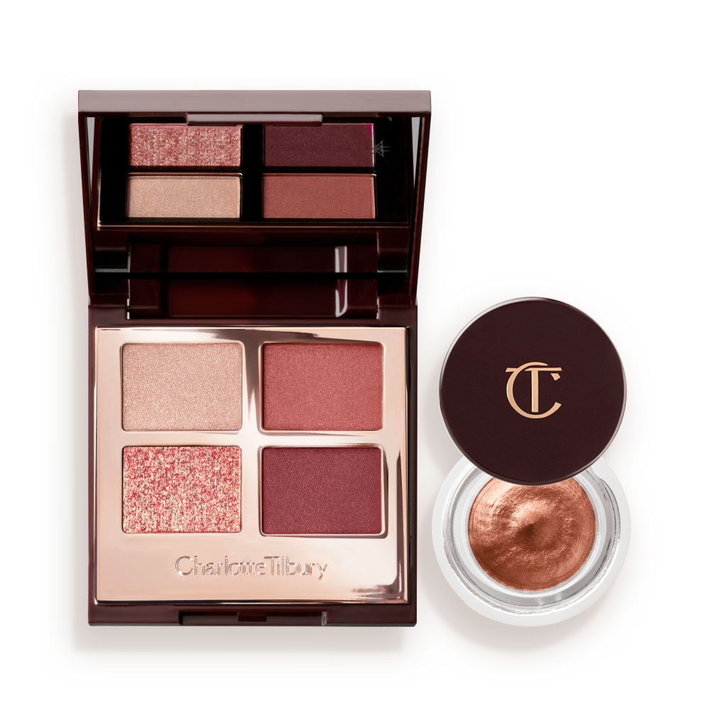 CHARLOTTEa__S_DREAMY_MESMERISING_EYE_DUO An open, mirrored-lid quad eyeshadow palette with beige, rose gold, russet brown, and maroon shades and cream eyeshadow in a nude pink shade in a petite, open pot with its lid removed.