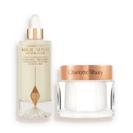 A large serum in a glass bottle with a golden and white-coloured dropper lid and pearly-white face cream in a glass jar with a rose-gold-coloured lid. 