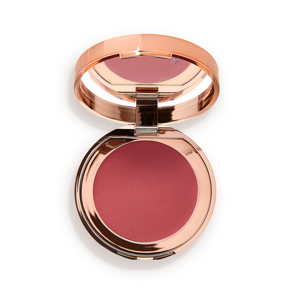 Colour-of-dreams-Packshot An open, mirrored-lid lip and cheek cream compact in a warm rosebud-pink shade.