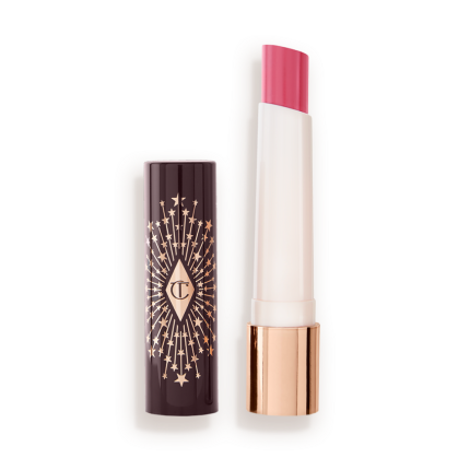 An open lipstick lip balm in a sheer nude pink berry shade, in white and gold tube with a black-coloured lid with gold sparkles all over it.