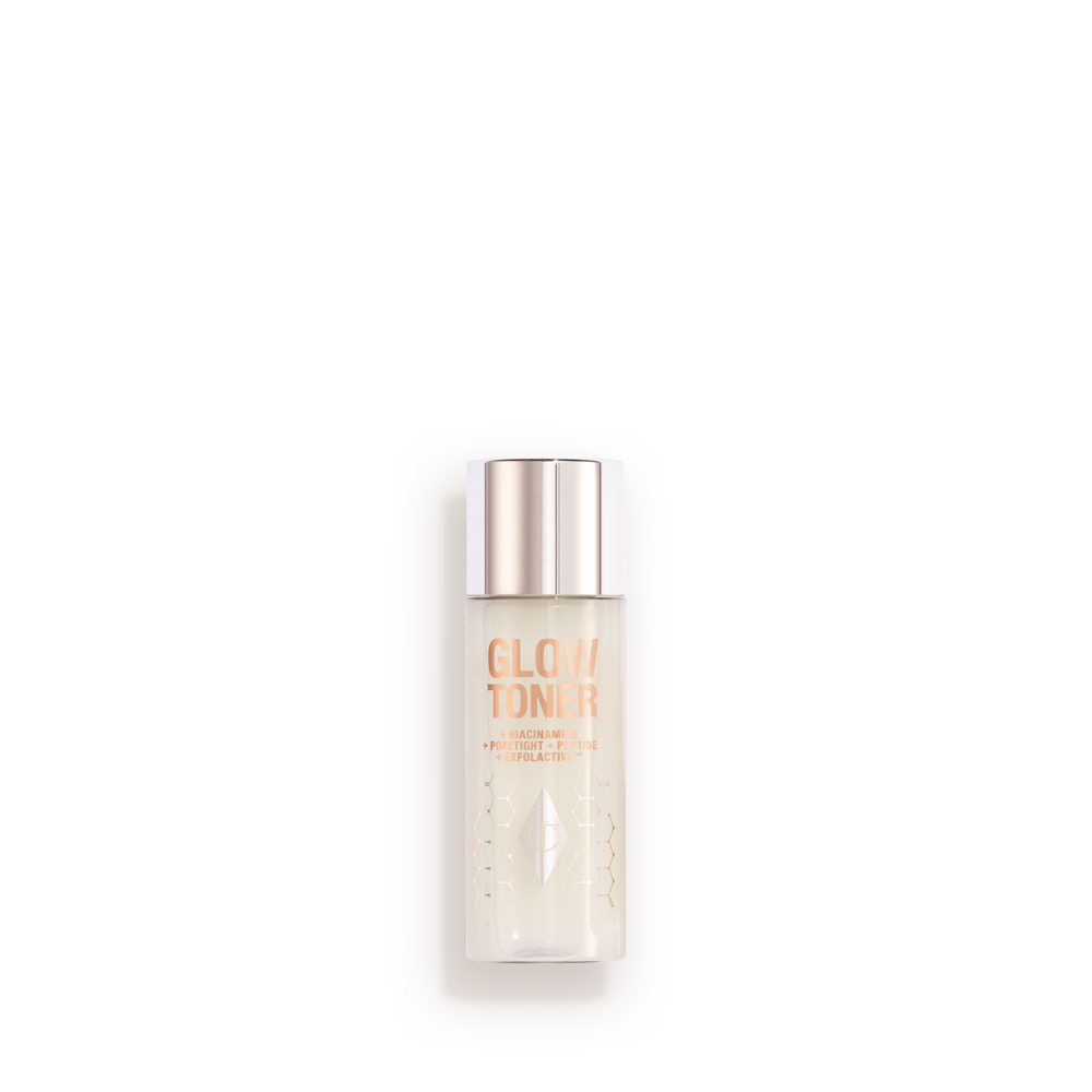 GLOW_TONER_30ML A large, clear bottle filled with luminous, cream-coloured watery toner with a silver-coloured lid.