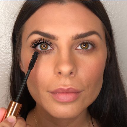 A medium-tone model with brown eyes with jet-black, volumising mascara on one eye and no mascara on the other.