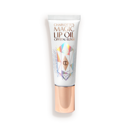 A lip oil in a white coloured tube with reflective geometric patterns on it in silver colour and a rose-gold-coloured lid.