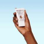 Model holding Invisible UV Flawless Primer with SPF50 sun protection