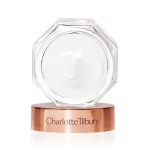 Thick, pearly-white cream in an open glass jar with its rose-gold-coloured lid next to it.