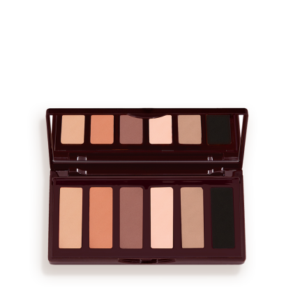 An open, mirrored-lid six-pan eyeshadow palette with matte eyeshadows in brown, peach, and beige shades.