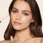 Fair-tone model with brown eyes wearing a radiant, concealer that brightens, covers blemishes, and makes her skin look fresh along with nude lip gloss and subtle eye makeup.