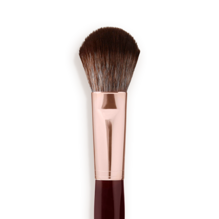 Close-up of a bronzer and blush brush with dark brown and grey bristles with a rose-gold and dark crimson handle.