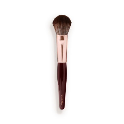A bronzer and blush brush with soft bristles and rose gold and dark crimson handle.