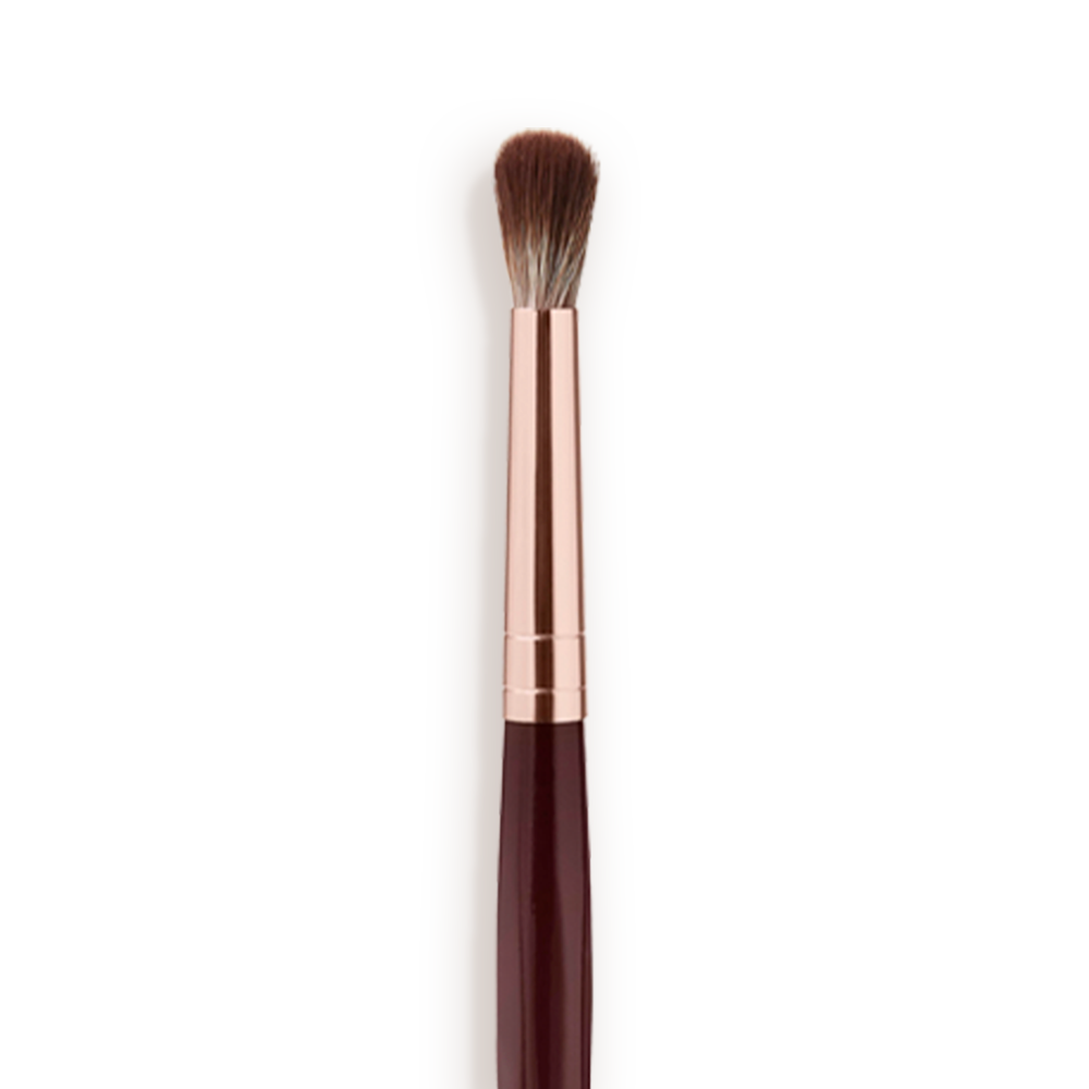 Synthetic_Eye_Blender_Brush_Close_Up_Packshot Close-up of an eyeshadow blending brush with soft bristles and a rose-gold and dark crimson handle.