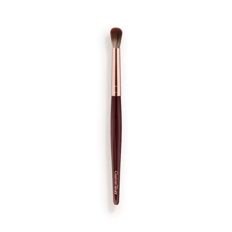 An eyeshadow blending brush with a golden and dark crimson-coloured handle.