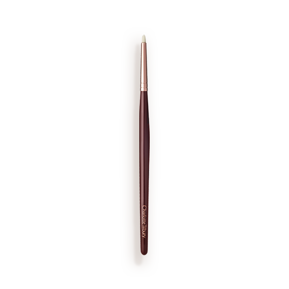 Synthetic_Eyeliner_Brush_Packshot A slim eyeshadow brush with white-coloured bristles with a rose-gold and dark crimson handle.