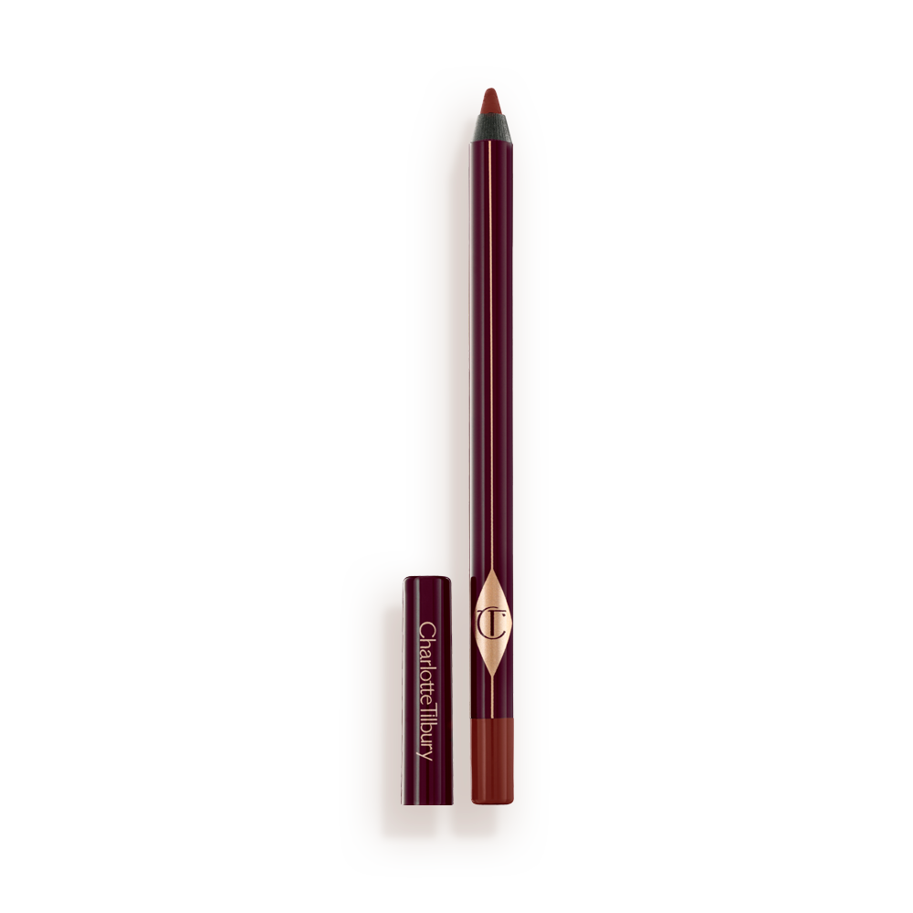 WALK_OF_NO_SHAME_EYELINER_OPEN An eyeliner pencil in a berry-pink shade with its lid next to it.