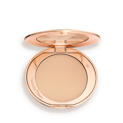 An open, pressed powder compact in a light beige shade.